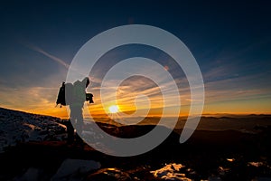 Red sunset and the silhoute of  photographer enthusiast stay on cliff and thinking