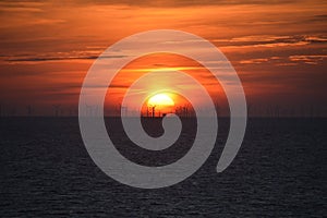 Red sunset with windfarm at sea