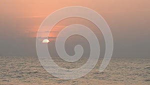 Red sunsets over sea. The sun touches horizon. Red sky, yellow sun and amazing sea. Summer sunset seascape. Atlantic Ocean beach s