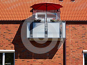 Red sunshade parasol on a modern balcony