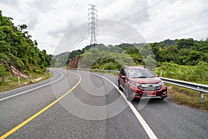 Red Suv car on Asphalt road with mountain green forest Transportation to travel concept