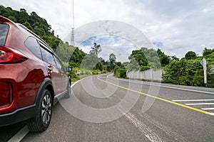 Red Suv car on Asphalt road with mountain green forest Transportation to travel concept