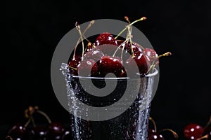 Red sweet cherries in a metal bucket on black background. Summer taste. Fresh berries