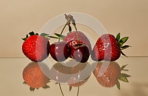 Red sweet cherrys  and strawberrys mirrored in the glass