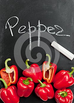 Red sweet pepper on a black background with chalk