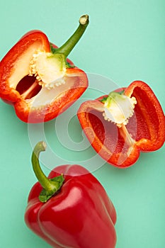 Red sweet pepper on mint background. Space for text. Flat lay. Vertical photo