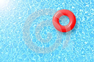 Red swimming pool ring float in blue water and sun bright. photo