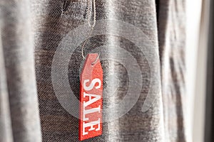 Red tag on the clothes with the inscription sale on the fishing hook.