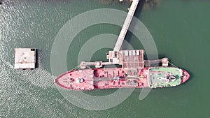 Red tanker ship loading and unloading oil and gas storage at industrial dock por