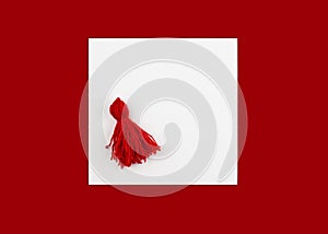 Red tassel Baba Marta symbol Martenitsa on white card. International Martisor day celebrate spring arrival. Greetting