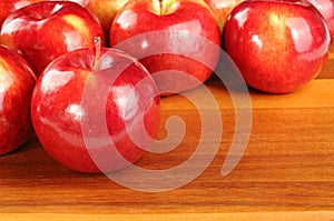 Red tasty apples on wooden table