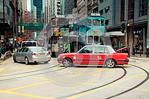 Red taxi and trams in Hong Kong busy streets, China