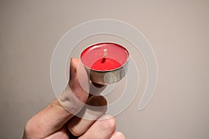 Red Tea Candle being hold in hand