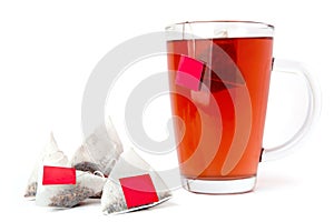 Red tea glass cup with tea bags isolated on white background.