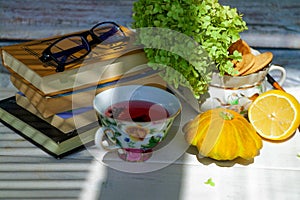 Red tea and reading glasses on the table in a cozy home.