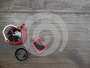 Red tea set on a wooden table. Red teapot, cup and chinese tea. Top view with copy space