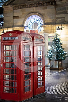 Red telephone booths in front of Christmas decorations in the Covent Garden area, London