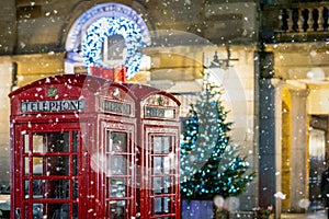 Red telephone booths in front of Christmas decorations lights in London, United Kingdom