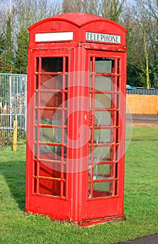 Red telephone box in the UK with cracked windows.