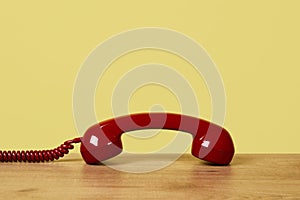 Red telephone off the hook on a yellow background