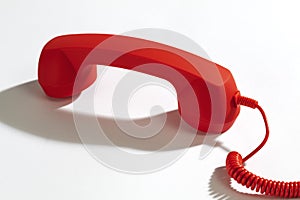 Red telephone receiver on white background