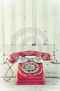 Red telephone on wooden chair