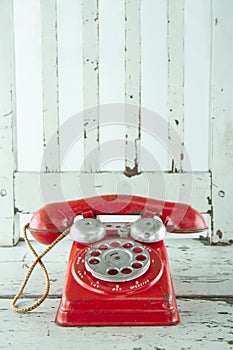 Red telephone on wooden chair