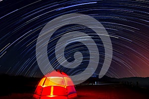 Red tent of adventurers on the background of beautiful star trails