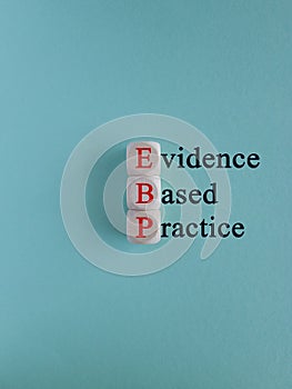 Red text EBP Evidence-based practice concept on wooden cubes. Beautiful blue background. Business concept