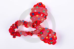 Red textile hair scrunchy with a pattern of flowers.