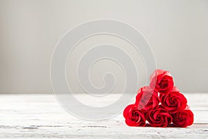 Red textured roses close-up and copy space. Womens day, mother`s day, red roses on a white wooden background