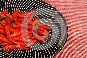 Red Thai peppers on black and white plate