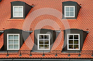 Red tile roof and gabled dormer windows on building in Munich, Germany