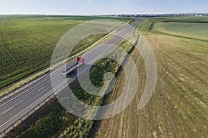 Red tipper truck on street road highway transportation. Semi-truck countryside aerial view