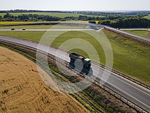 Red tipper truck on street road highway transportation. Semi-truck countryside aerial view