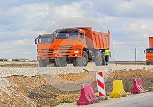 Red tippers o road under construction.