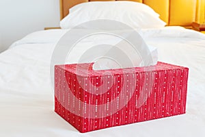 Red tissue paper box on spacious bed