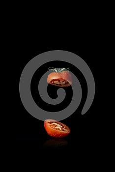 Red tomato cut in half on black background