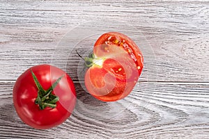 Red tomato cut in half close up on a wooden table