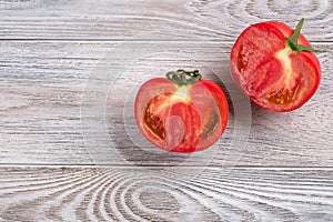 Red tomato cut in half close up on a wooden table