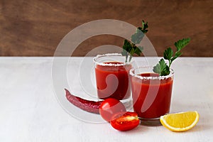 Red tomato juice and fresh tomatoes on the white