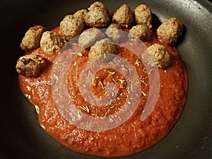 Red tomato pasta sauce and meatballs in skillet or pan