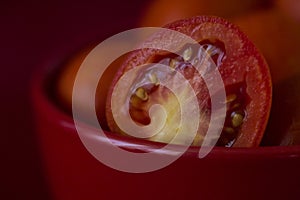 Red Tomato Slice in Red Bowl with Red Background