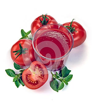 red tomatoes in basket and tomato juice in glass and jug on white