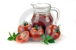 Red tomatoes in basket and tomato juice in glass and jug on white