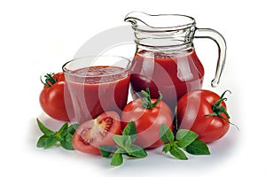 red tomatoes in basket and tomato juice in glass and jug on white