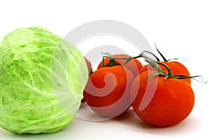 Red tomatoes on a branch, and young cabbage sprouts on white background