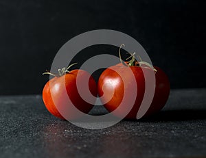 Red tomatoes on dark background