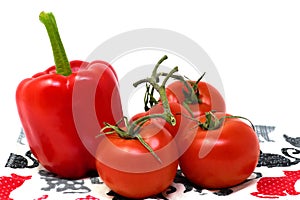 Red tomatoes and peppers on the tablecloth with cats. Isolated. Vegan food. photo