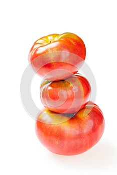 Red tomatoes on top of big delicious tomato, isolated on white.